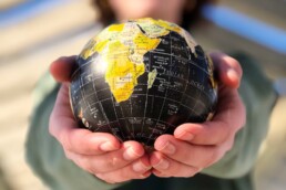 person holding yellow and black desk globe