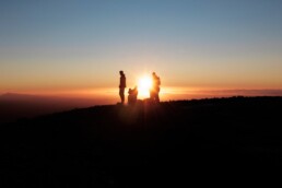 a couple of people standing on top of a hill